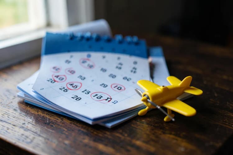 Seção 2: Um calendário aberto com dias marcados e um avião de brinquedo ao lado, sobre uma mesa.